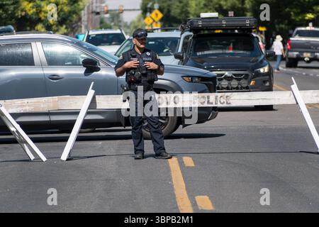 Provo, UT – 4 juillet 2025 : un policier de Provo se tient au milieu de la route qui dirige la circulation pendant la Grande Parade du Freedom Festival à Provo. Banque D'Images