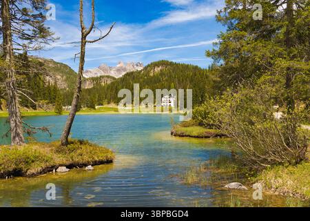 Pittoresque Lago Misurina avec ses eaux claires, encadré par des pins et des montagnes rocheuses lointaines, avec un charmant bâtiment sur la rive lointaine UEDN Banque D'Images