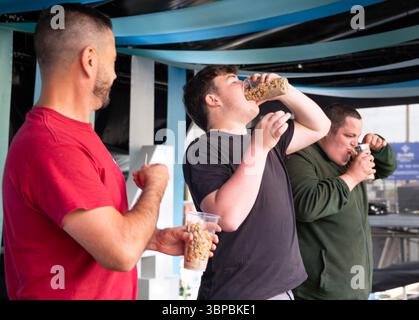 Les concurrents participent à la compétition « mangez une pinte de coques » à la régate Old Leigh, Leigh on Sea. Banque D'Images