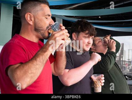 Les concurrents participent à la compétition « mangez une pinte de coques » à la régate Old Leigh, Leigh on Sea. Banque D'Images