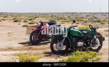 Deux motos de style ancien garées dans un champ de style désert Banque D'Images