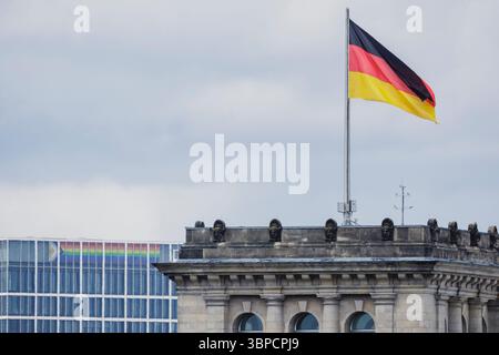 Berlin, Deutschland. 07 juillet 2025. Le drapeau de l'Allemagne sur le Bundestag allemand vole à côté d'un drapeau arc-en-ciel vu sur un bâtiment en arrière-plan à Berlin, 07.07.2025. Crédit : dpa/Alamy Live News Banque D'Images