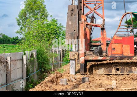 Une machine de battage de pieux installe actuellement des pieux de fondation sur le chantier de construction. Banque D'Images