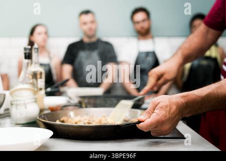 gros plan des mains pendant le cours de cuisine avec un groupe de personnes apprenant à cuisiner Banque D'Images