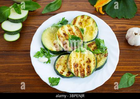 Tranches de courgettes grillées sur fond de bois foncé. Banque D'Images