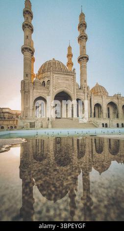 La mosquée Heydar à Bakou, en Azerbaïdjan, capturée pendant l'heure d'or avec ses quatre imposants minarets et ses pierres complexes reflétant magnifiquement sur t Banque D'Images