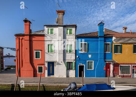 Maisons de charme traditionnelles avec cheminées dépassant des façades sur l'île de Burano dans la lagune de Venise en Italie. Banque D'Images