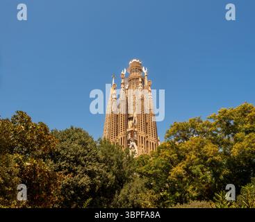 Une vue sur les tours de façade de la Nativité de la basilique de la Sagrada Familia, chef-d'œuvre inachevé d'Antoni Gaudí, s'élevant au-dessus d'un parc à Barcelone, en Espagne. Banque D'Images