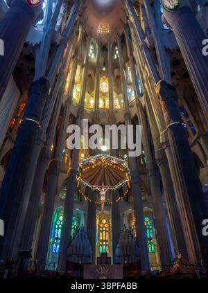 Une vue large de l'autel principal, du crucifix et de l'orgue à pipe, regardant vers l'abside de la Sagrada Familia d'Antoni Gaudí, Barcelone, Espagne. Banque D'Images