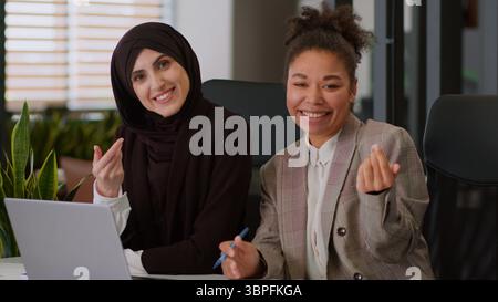 Deux femmes d'affaires heureuses multiraciales multiethniques filles collègues collègues collègues de bureau femmes musulmanes employés africains joyeux partenaires d'affaires Banque D'Images