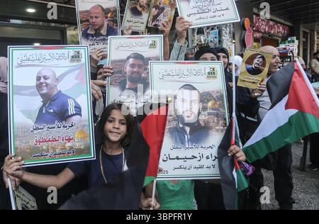Naplouse, Palestine. 08 juillet 2025. Les familles de prisonniers palestiniens tiennent des photos de leurs proches emprisonnés lors d'un rassemblement de solidarité. Les Palestiniens ont organisé une manifestation pour exiger un accord d'échange de prisonniers avec le gouvernement israélien et le Hamas. Crédit : SOPA images Limited/Alamy Live News Banque D'Images