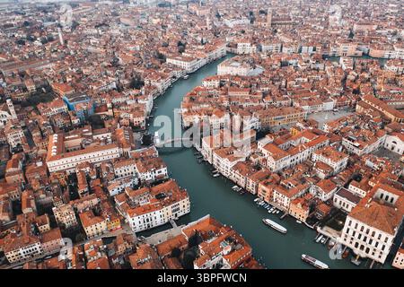 Vue aérienne du Grand canal serpentant à travers une tapisserie de toits en terre cuite et de bâtiments historiques, Venise, Italie. Banque D'Images