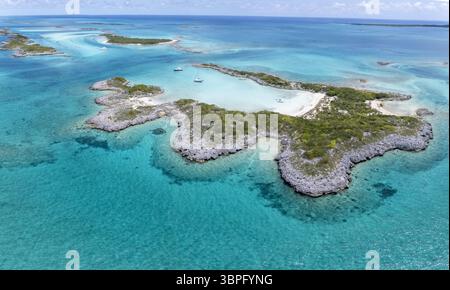 Vue aérienne des eaux turquoises embrassant des côtes accidentées et de petits bateaux, une tapisserie de bleus et de verts sous le soleil des Bahamas, Black point, Bahamas. Banque D'Images