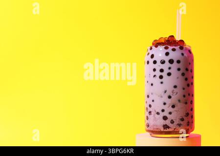 Thé à bulles de lait savoureux en verre sur fond jaune, espace pour le texte Banque D'Images