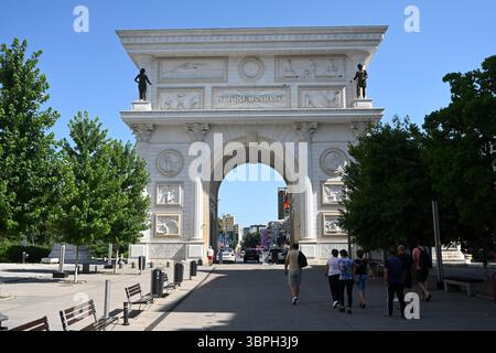 Skopje, Macédoine du Nord - 15 juin 2025 : les gens près de la Porta Macedonia et un arc commémoratif situé sur la place Pella à Skopje. Banque D'Images