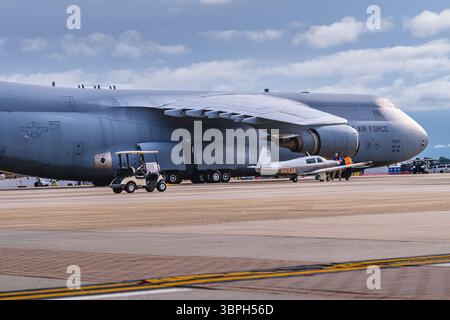 Image éditoriale, USAF C-5M Super Galaxy et avion civil N431JA sur la rampe de McGuire AFB, New Jersey, mai 2025. Banque D'Images