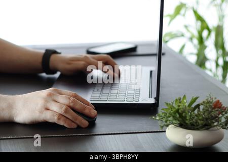 Gros plan des mains tapant sur le clavier de l'ordinateur portable dans Modern Workspace Banque D'Images