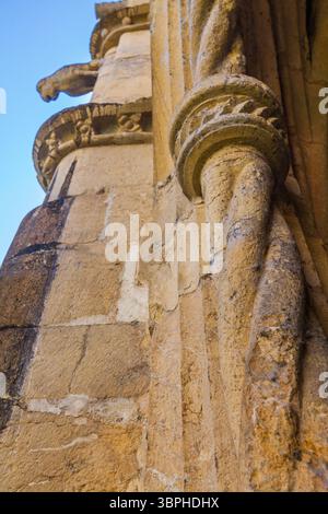 gros plan détaillé d'une ancienne colonne de pierre avec des sculptures en spirale complexes et des textures altérées, sur un ciel bleu vif Banque D'Images
