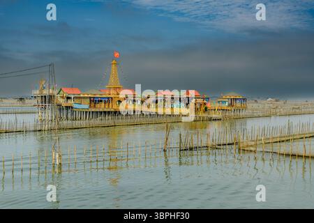 Restaurant maison sur pilotis sur un lagon à Thuy Dien, Hue, Vietnam. Le restaurant est construit sur pilotis au-dessus de l'eau, entouré de poteaux de bambou utilisés pour Banque D'Images