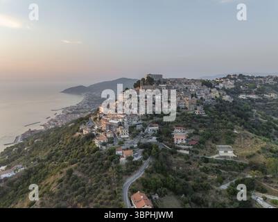 Vue aérienne du charmant village perché sur une colline, embrassé par la lueur chaude du soleil couchant, surplombant la mer Tyrrhénienne, Santa Maria di Castellabate, Salerne, Italie. Banque D'Images