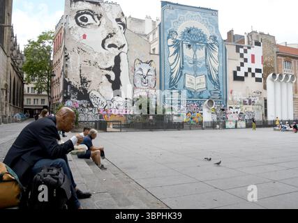 Paris, États-Unis. 26 juin 2025. Un homme déjeune entre le Ã^ proximité Saint-Merry et la Fontaine Stravinsky, près du Centre Pompidou à Paris. Les peintures murales sont sur la place Igor Stravinsky. (Crédit image : © Mark Hertzberg/ZUMA Press Wire) USAGE ÉDITORIAL SEULEMENT ! Non destiné à UN USAGE commercial ! Banque D'Images