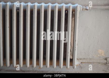Vieux radiateur monté sur un mur dans une pièce vintage Banque D'Images