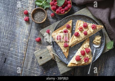 Petit déjeuner sandwich dessert sucré d'été. Savoureux grillé au beurre d'arachide et à la framboise sur une table rustique en bois. Copier l'espace Banque D'Images