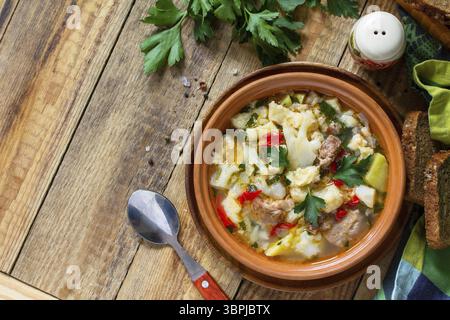 Soupe épaisse hongroise traditionnelle avec du bœuf, des légumes et des boulettes sur une table en bois. Dîner ou déjeuner chaud. Plat, vue de dessus. Copier l'espace Banque D'Images