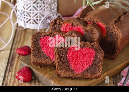 Dessert Saint-Valentin, anniversaire ou fête des mères, plats festifs faits maison. Gâteau au brownie au chocolat sucré fait maison avec coeur rouge sur un rustique en bois Banque D'Images