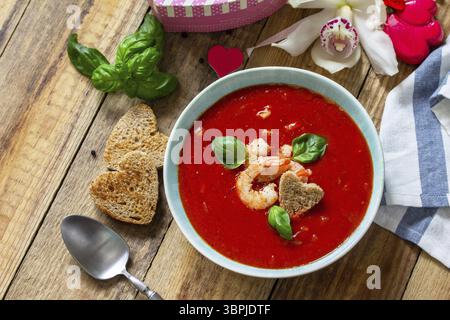 Soupe de Saint-Valentin maison, cuisine festive. Gazpacho de purée de soupe de tomates avec tomates servies fruits de mer sur une table en bois rustique. Copier l'espace Banque D'Images