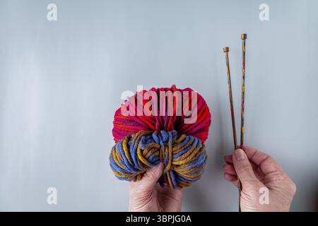 Les mains d'une femme âgée tiennent des écheveaux de fil de laine et des aiguilles à tricoter, espace de copie Banque D'Images