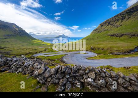 Vue d'une route sinueuse menant à l'île de Koltur en arrière-plan. Streymoy, Torshavnar district, Îles Féroé, Danemark, Scandinavie. Banque D'Images