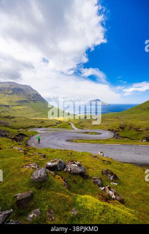 Vue d'une route sinueuse menant à l'île de Koltur en arrière-plan. Streymoy, Torshavnar district, Îles Féroé, Danemark, Scandinavie. Banque D'Images
