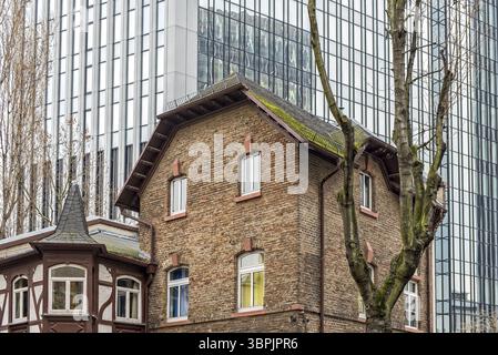 Ancien bâtiment résidentiel en briques avec extension à colombages devant la façade d'une tour de bureaux moderne, Francfort-sur-le-main, Allemagne, Europe Banque D'Images