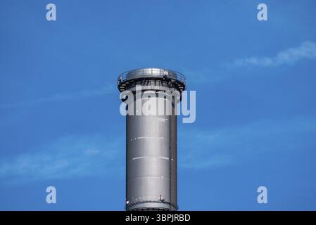 Le sommet d'une cheminée ou d'une cheminée d'usine photographié au centre devant un ciel bleu avec des nuages clairs, Francfort-sur-le-main, Allemagne, Europe Banque D'Images