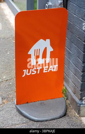 Londres, Royaume-Uni - 2 juin 2025 : signe Just Eat à l'entrée d'un restaurant à Londres, Royaume-Uni. Banque D'Images