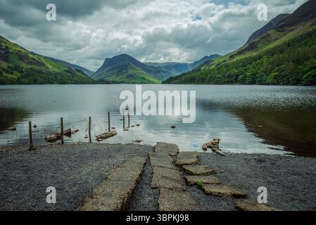 Une vue paisible sur le lac Buttermere depuis sa plage du côté nord, capturée lors d'une journée d'été couverte Banque D'Images