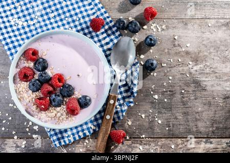 Bol à smoothie sain avec des baies sur une table en bois Banque D'Images