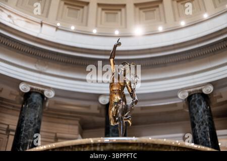 National Gallery of Art Mercury sculpture Washington DC // WASHINGTON DC — la sculpture en bronze de Mercure, créée vers 1780-1850 après Giovanni Bologna, se trouve bien en vue dans la fontaine centrale de la rotonde West Building de la National Gallery of Art. Mesurant 70½ pouces de haut, la figure dynamique se balance sur un pied avec des ailes sur ses chevilles et son casque, créant une composition en spirale alors qu'il pointe vers le mont Olympe. La sculpture, qui est devenue la mascotte officieuse de la Galerie lorsque le bâtiment a ouvert ses portes en 1941, représente le Dieu messager romain tenant un bâton de caducée avec des serpents enchevêtrés. P Banque D'Images