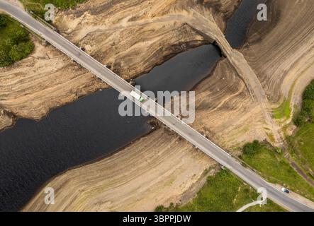 Terre fissurée sèche au réservoir Baitings à Ripponden, West Yorkshire. Les ménages du Yorkshire sont devenus les premiers à être frappés par une interdiction de canalisations par Yorkshire Water, après des mois de temps extrêmement chaud et sec à travers l'Angleterre. Date de la photo : mercredi 9 juillet 2025. Banque D'Images