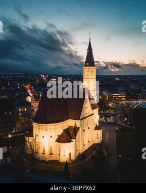 Siauliai, Lituanie - 12 novembre 2024 : vue aérienne du coucher du soleil illuminée Église catholique romaine des Saints Pierre et Paul. Siauliai City sites touristiques et Banque D'Images