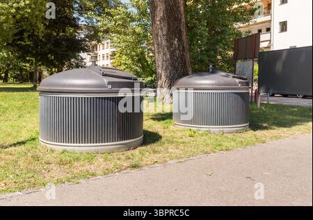 Deux grandes poubelles rondes grises pour le tri des déchets se dressent dans une rue de la ville de Locarno, en Suisse, dans le cadre d’une gestion moderne des déchets urbains Banque D'Images