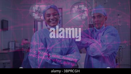 Debout deux chirurgiens portant des blouses de gommage pliant les bras dans la salle chirurgicale, avec des lumières chirurgicales Banque D'Images