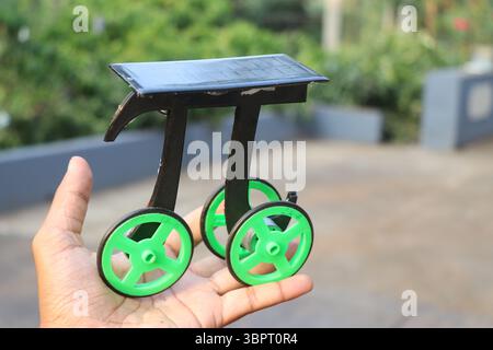 Petite voiture à énergie solaire ou voiture écologique tenue dans la main. Véhicule à cellules solaires construit à la maison Banque D'Images
