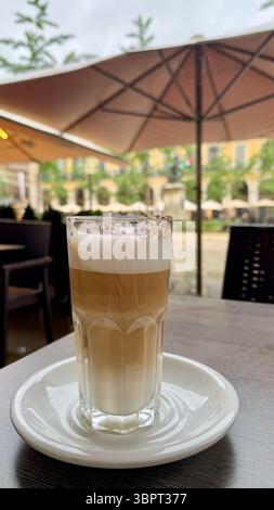 Verre de café glacé servi dans un café d'été en plein air. Boisson rafraîchissante avec glace par une journée ensoleillée, style de vie urbain et concept saisonnier. Banque D'Images
