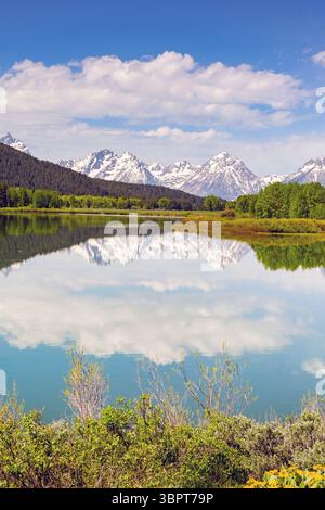 Vue panoramique sur les montagnes enneigées dans le parc national de Grand Tetons reflétée dans les eaux calmes d'un lac. Personne. Banque D'Images