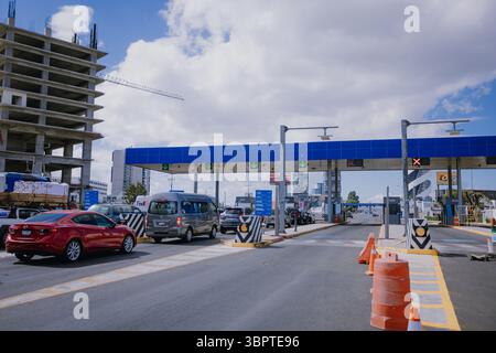 Les voitures s'alignent au péage de Atlixcáyotl à Puebla, au Mexique, montrant la signalisation routière et routière un jour régulier Banque D'Images
