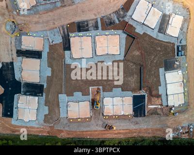 Vue aérienne du chantier de construction avec excavatrice creusant aux fondations d'un bâtiment, vue d'en haut Banque D'Images