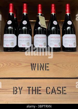 Bouteilles de vin rouge soigneusement disposées dans une caisse en bois étiquetée « VIN PAR CAISSE » sur une étagère de vente au détail. Dvino Wines, Preston, Royaume-Uni Banque D'Images