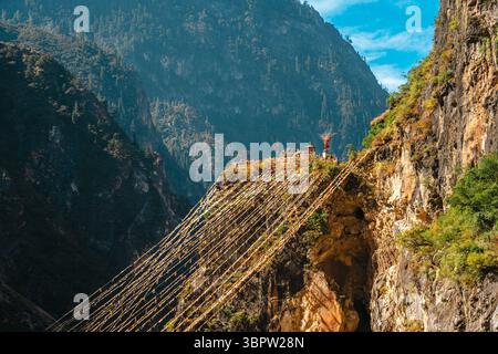 Des drapeaux de prière tibétains colorés s'étendent à travers un spectaculaire et profond canyon fluvial dans les montagnes du Yunnan. Balagezong, Shangri-La. Banque D'Images